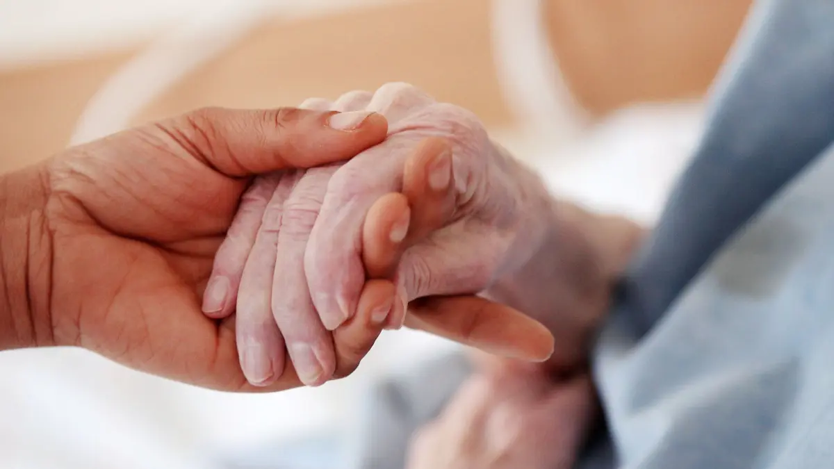 ARCHIV - ILLUSTRATION - 14.06.2011: Eine Pflegerin hält einem Altenheim die Hand einer Bewohnerin. Nach mehrwöchigen Ermittlungen haben die Ermittler keine Hinweise auf weitere Verdachtsfälle gegen eine Haushaltshelferin, die für den Tod eines pflegebedürftigen 87-Jährigen aus Dinslaken verantwortlich sein soll. Zwar habe die Polin alte Menschen in Nordrhein-Westfalen ebenso gepflegt wie in Baden-Württemberg und vermutlich in Bayern. Es deute aber nichts auf zusätzliche ungeklärte Todesfälle hin, die einen Mordverdacht zuließen, hieß es. (zu dpa "Mordverdächtige pflegte noch mehr Senioren" vom 19.05.2018) Foto: Oliver Berg/dpa +++ dpa-Bildfunk +++