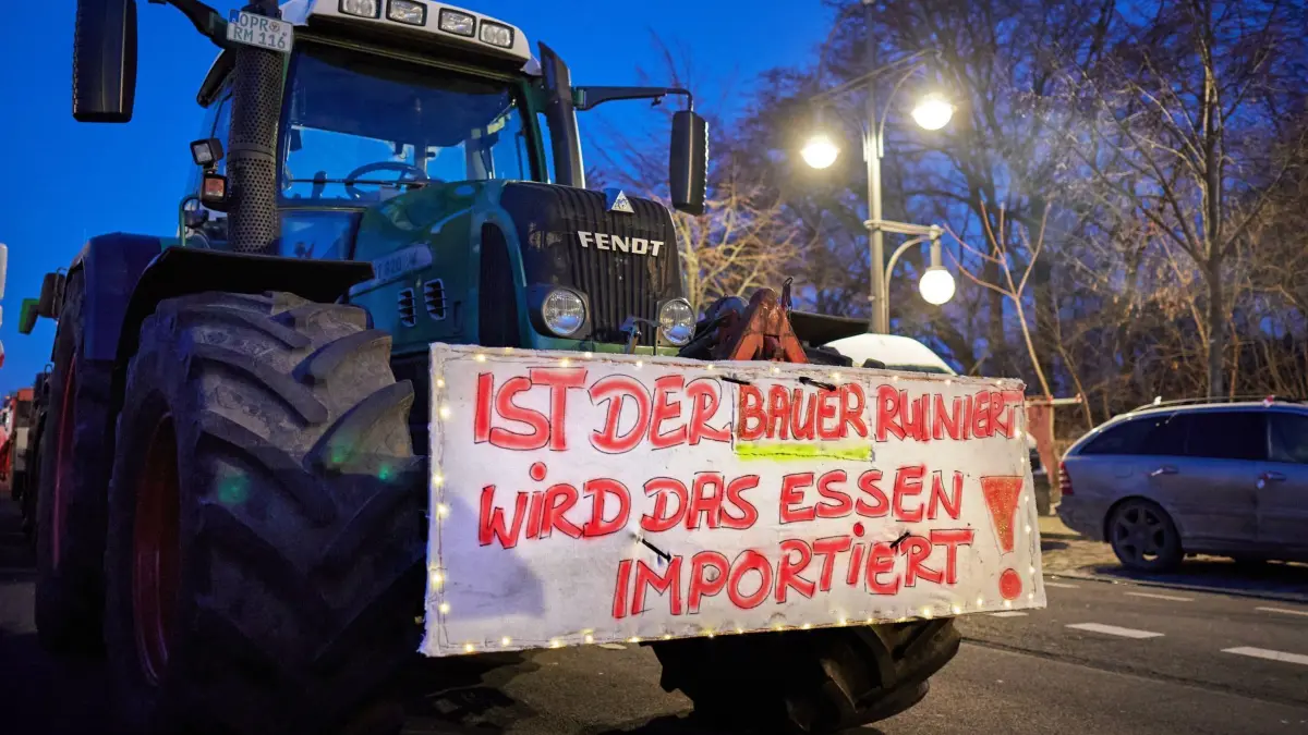 „Ist der Bauer ruiniert, wird das Essen importiert!“ steht auf einem Schild, das an einem der Traktoren angebracht ist, die bei einem Bauernprotest auf der Straße des 17. Juni vor dem Brandenburger Tor stehen. Als Reaktion auf die Sparpläne der Bundesregierung hat der Bauernverband zu einer Aktionswoche mit Kundgebungen und Sternfahrten ab dem 8. Januar aufgerufen. Sie soll am 15. Januar in einer Großdemonstration in der Hauptstadt gipfeln.