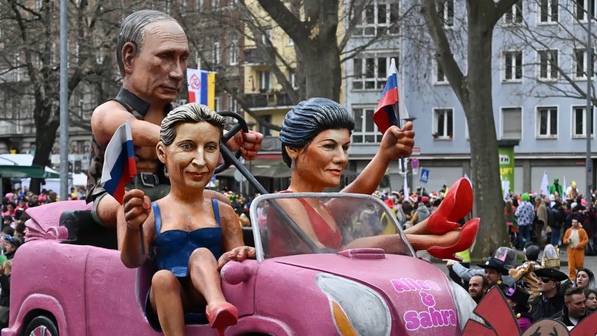 12.02.2024, Rheinland-Pfalz, Mainz: Der MCV-Motivwagen ·Barbies und ·Ken··, der Alice Weidel (AfD, 2.v.l), den russischen Präsidenten Wladimir Putin und Sahra Wagenknecht (BSW) aufs Korn nimmt, ist beim Mainzer Rosenmontagszug unterwegs. Foto: Arne Dedert/dpa +++ dpa-Bildfunk +++