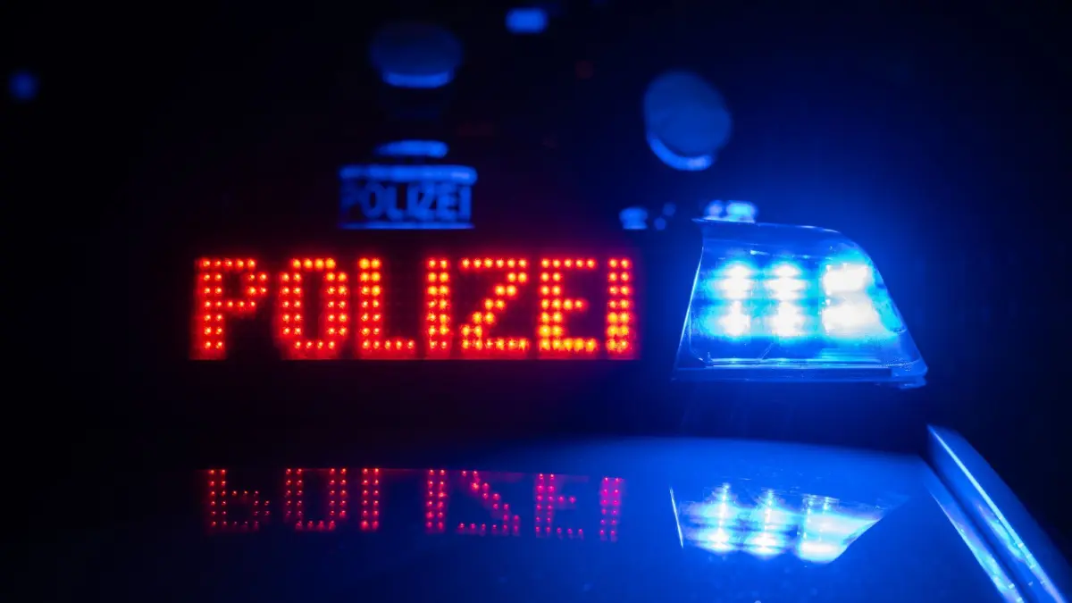 ILLUSTRATION - 30.11.2023, Baden-Württemberg, Stuttgart: Zwei Polizisten stehen im Rahmen eines Fototermins vor einem Polizeifahrzeug (gestellte Szene). (zu dpa: «19-Jähriger soll Eltern und Bruder getötet haben») Foto: Marijan Murat/dpa +++ dpa-Bildfunk +++