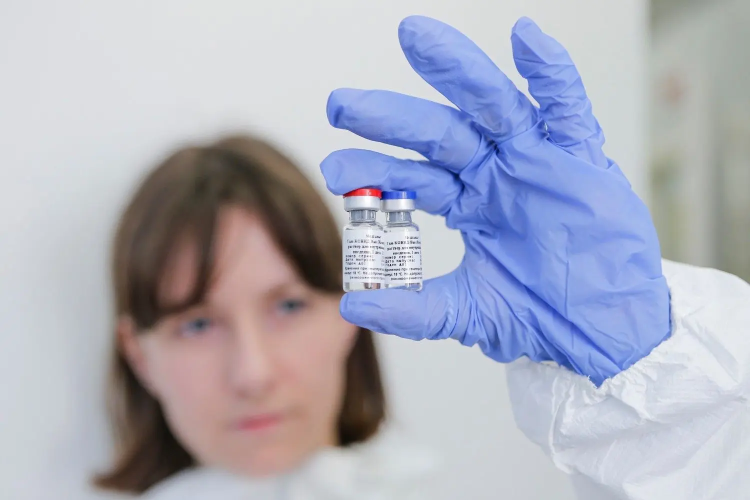Die vom russischen Investmentfonds Russian Direct Investment Fund zur Verfügung gestellte Aufnahme zeigt eine Mitarbeiterin des Nikolai Gamaleya Nationalzentrums für Epidemiologie und Mikrobiologie, während sie zwei Ampullen mit einem neuen Impfstoff gegen das Coronavirus in ihrer Hand hält.