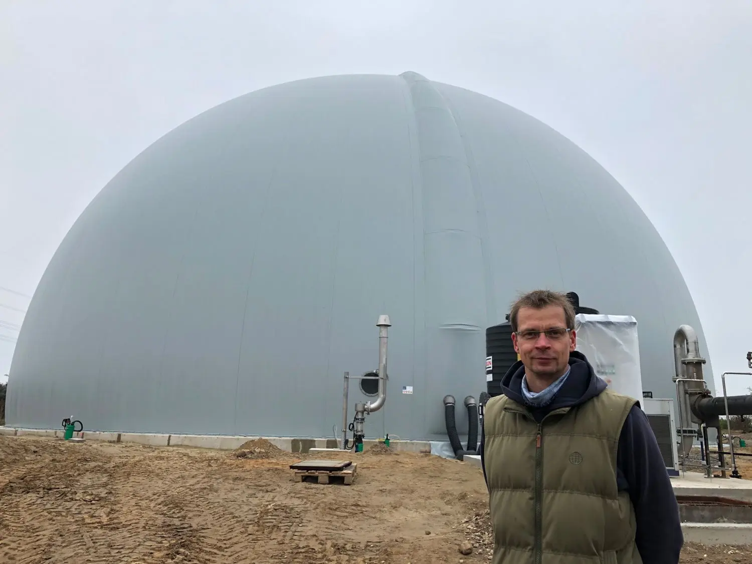Riesiger Gastank: Fabian Meise, Geschäftsführer der BBE Buchholzer Bioenergie GmbH, steht vor dem Tank, in dem Gas zur Stromproduktion gespeichert wird.