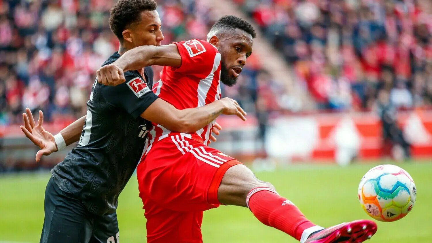 Jordan Siebatcheu (rechts) von Union Berlin schirmt mit vollem Körpereinsatz den Ball gegen Frankfurts Tuta ab.