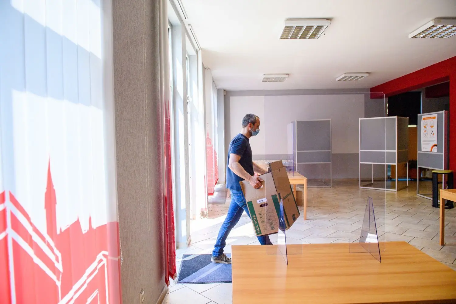 Ein Mitarbeiter der Stadt Magdeburg trägt einen Karton in ein Wahllokal. In Sachsen-Anhalt wird am 6. Juni 2021 ein neuer Landtag gewählt. Die Landesregierung wird derzeit von einem sogenannten Kenia-Bündnis (CDU, SPD, Grüne) gestellt.