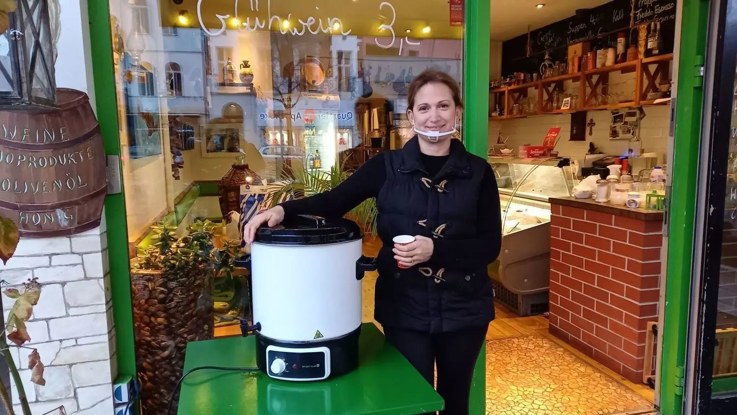 Julie Trantafillidou hat einen Kessel mit dem Glühwein vor ihr kleines Kretanisches Restaurant in der Schöneberger Maaßenstraße in Berlin gestellt.