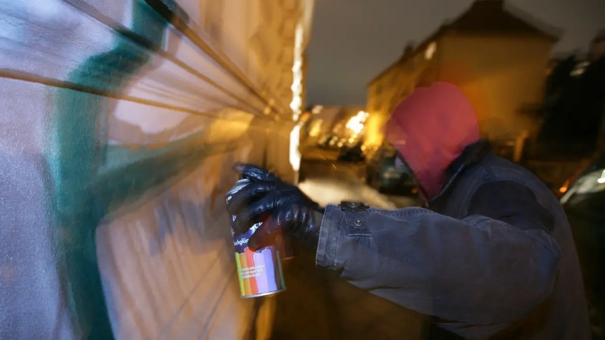 In Petershagen sind Jugendlichen beim Sprayen erwischt worden (Symbolbild).
ARCHIV - ILLUSTRATION - Ein Graffiti-Sprayer verschandelt in der Nacht eine Hauswand in Frankfurt (Oder), (Foto vom 11.01.2006. Sprayer nutzen fast jede Wand für ihre Farbmarken. Viele Städte in Thüringen leiden verstärkt unter Graffitisprayern, ergab eine Umfrage der Deutschen Presse-Agentur dpa. Rund 5000 Fälle hat das thüringische Landeskriminalamt im vergangenen Jahr gezählt, 900 mehr als 2007. Die Schadenssumme wird auf mehr als zwei Millionen Euro geschätzt. Nur jede dritte Tat konnte aufgeklärt werden. Insgesamt wurden 535 Täter gefasst. Kommunen und Hausbesitzer stehen den nächtlichen Aktionen oft machtlos gegenüber. Foto: Patrick Pleul/lbn (zu lth 4051 "Millionen-Schäden durch Graffiti in Thüringen" vom 08.08.2009) +++(c) ZB-FUNKREGIO OST - Honorarfrei nur fuer Bezieher des ZB-Regiodienstes+++