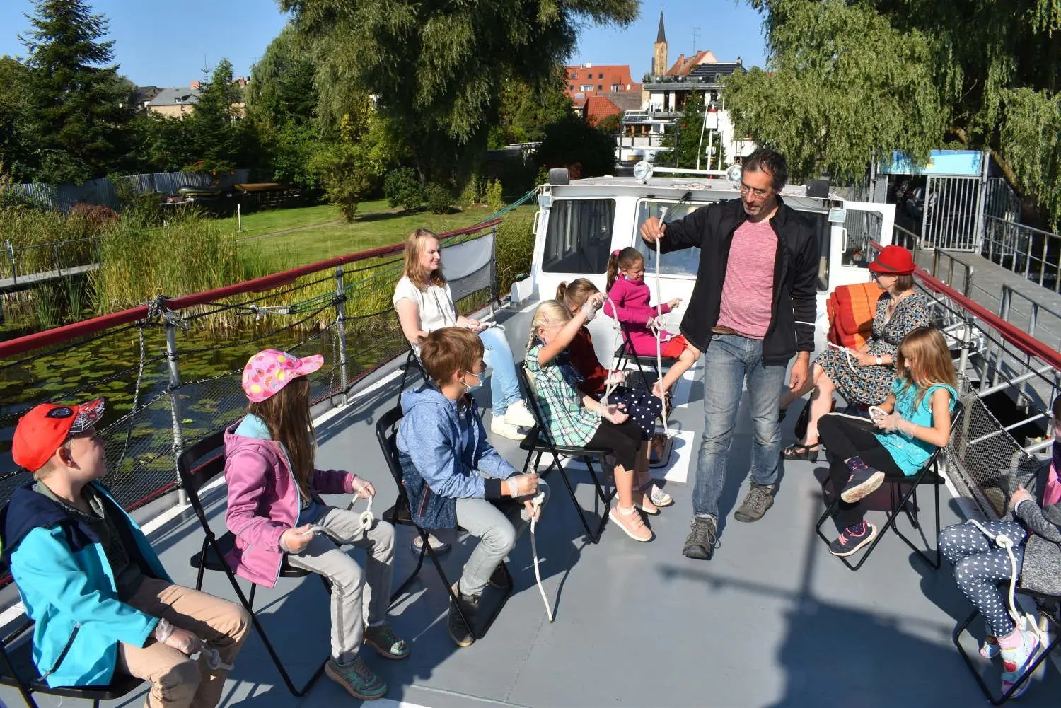 Knotentechnik statt Seemannsgarn: Kapitän Felix Eisenhardt (stehend) bringt den Kindern unter anderem bei, wie sie mithilfe der Sonne navigieren können und wie sich aus Seilen Knoten formen lassen.