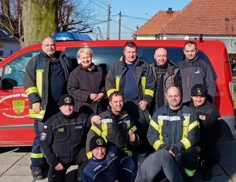 Gruppenbild mit polnischer Bürgermeisterin und Berufsfeuerwehr: Die mitgereisten Kameraden der Freiwilligen Feuerwehr Rüdersdorf sind an der Kleidung mit den gelben Reflektorstreifen zu erkennen.