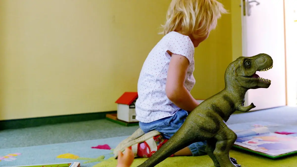 Ein kleines Mädchen spielt in einer Inobhutnahmestelle.
Ein kleines Mädchen schaut sich am 24.07.2014 in der Kinderschutzeinrichtung in Frankfurt am Main ein Buch an, daneben steht ein Dinosaurier aus Plastik. Rund um die Uhr finden Kinder in dem Heim Zuflucht, die zu Hause Gewalt, Verwahrlosung, Drogen, Alkoholismus oder sexuellem Missbrauch ausgesetzt sind. Für 29 Mädchen und Jungen - vom Säugling bis zum Zwölfjährigen - ist Platz. Dazu kommen noch drei Notplätze. Foto: Roland Holschneider/dpa (zu dpa-Korr vom 25.07.2014: Zum Schutz im Heim - "Kinder bringen unsichtbaren Rucksack mit") +++(c) dpa - Bildfunk+++ | Verwendung weltweit