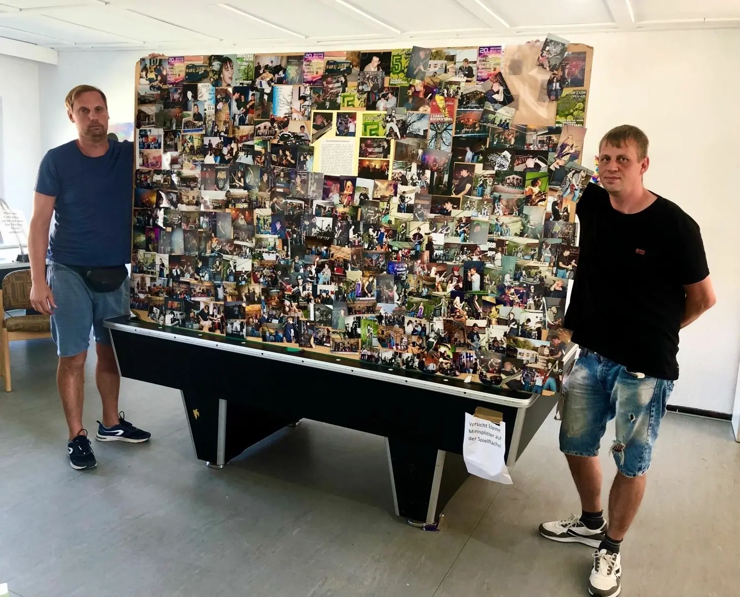 Sebastian Henning (li.) und Tammo Lampe haben eine Leinwand mit Fotos aus 20 Jahren Rockende Eiche in Biesenthal vorbereitet.