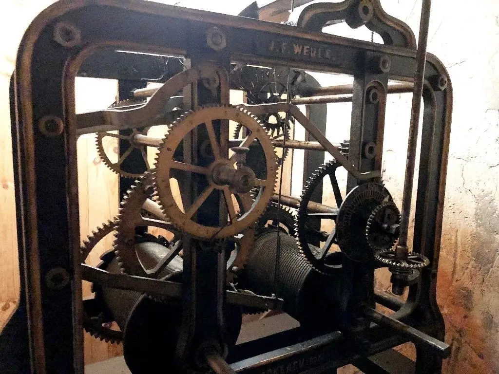 Blick auf das mechanische Räderwerk der Uhr im Turm, mit dem die Zeiger in Gang gehalten werden.
