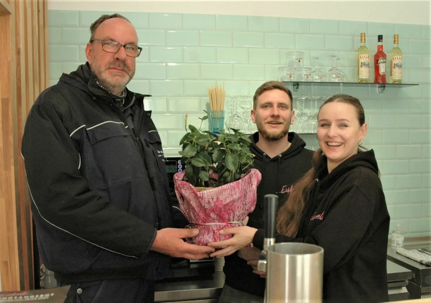 Blumen zur Eröffnung: Ronny Hiekel vom Vorstand des Stadtteilvereins Finow gratuliert Lukas Kasperczyk und Nicole Najdowski (von links), die jetzt auch an der Eberswalder Straße 72 eine EiskaltFiliale betreiben.