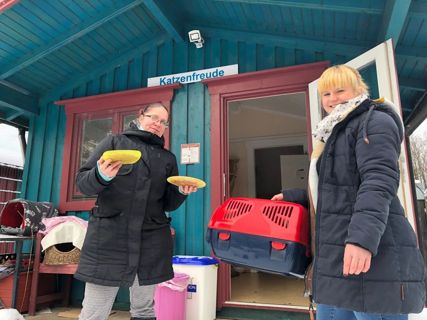 Fleißige Helfer: Nancy Otto (l.) und Steffi Müller mit Futter und Katzenbox an einem der Häuschen