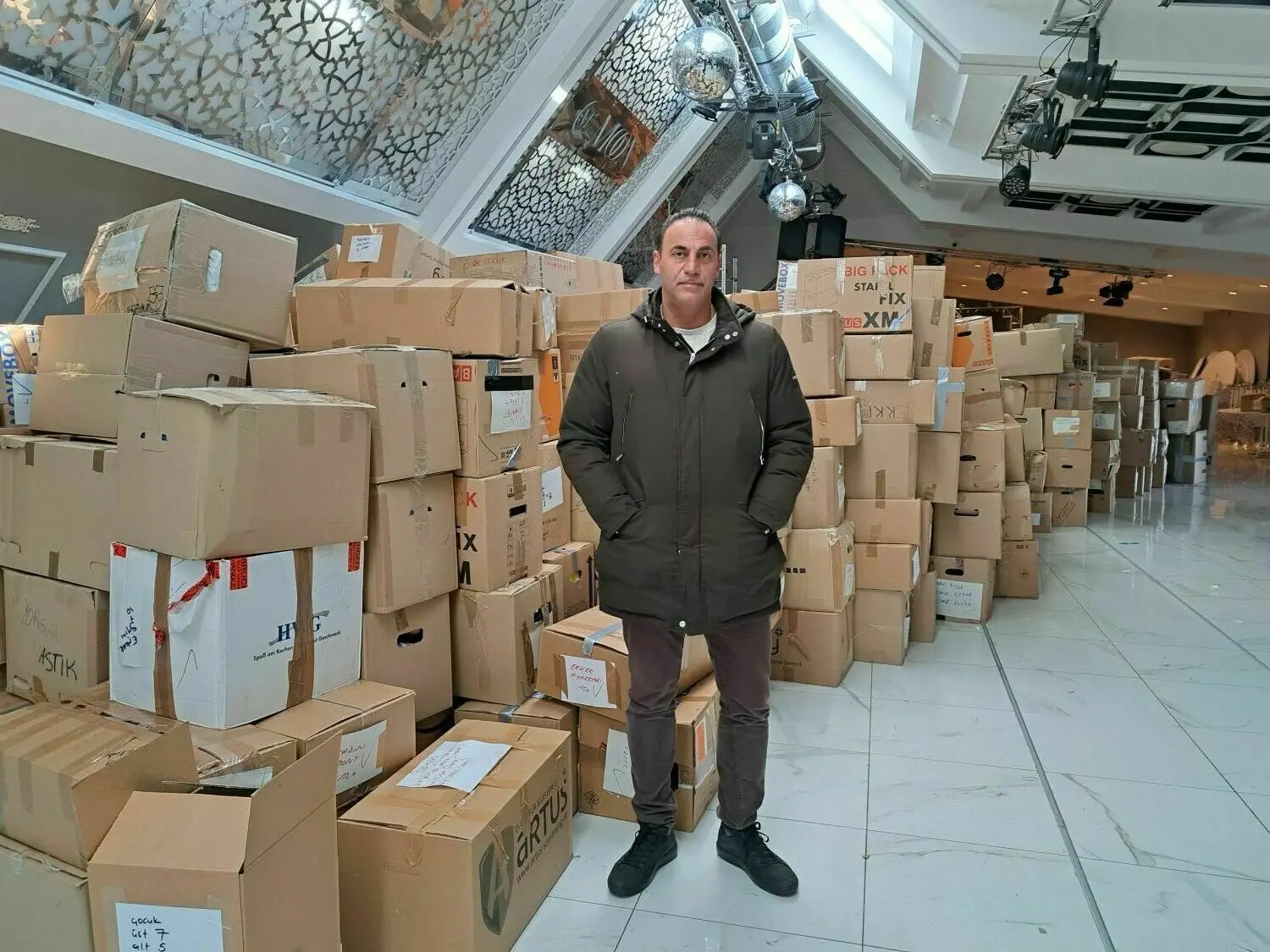 Senol (47) von der Firma Moon Events sammelt in seinem Veranstaltungssaal in Berlin-Kreuzberg seit Montag Hilfsgüter für die Erdbebenopfer in der Türkei. Er uns seine Mitarbeiter haben unter anderem Windeln und Babynahrung in Kisten verpackt, die gerade auf Abholung warten.