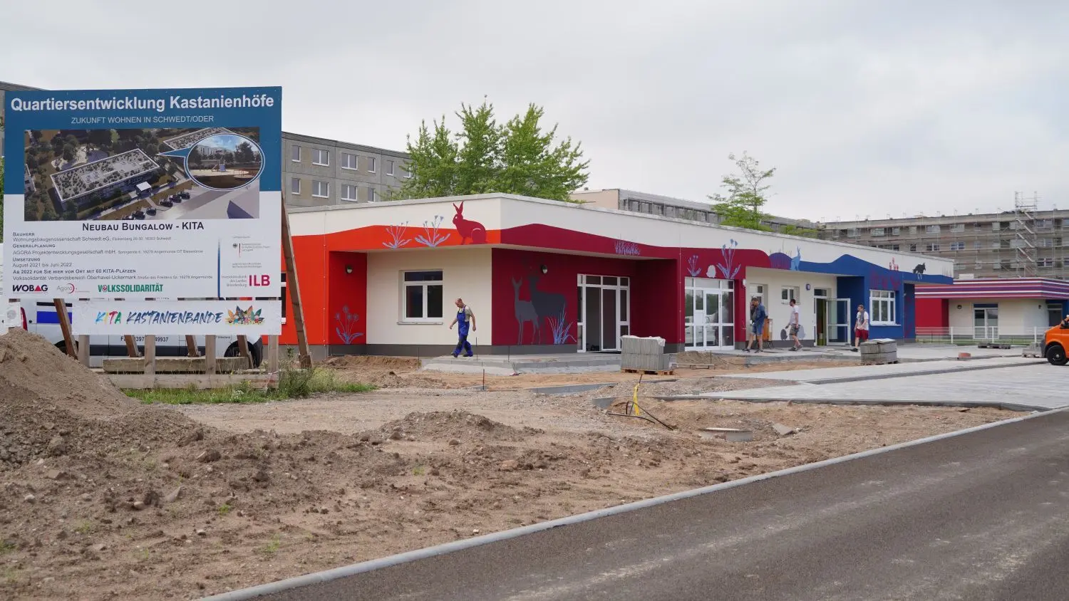 Die Straße vor der Kita ist fertig, die Parkplätze angelegt. Tiere des Waldes schmücken die bunte Fassade.