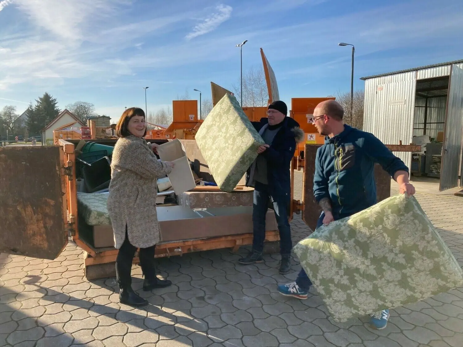 Geschäftsführerin der APM, Diana Grund, Hannes Strunz (örE) und Bastian Heese (APM) zeigen wie es richtig geht: Müll in den Container und nicht in die Natur.