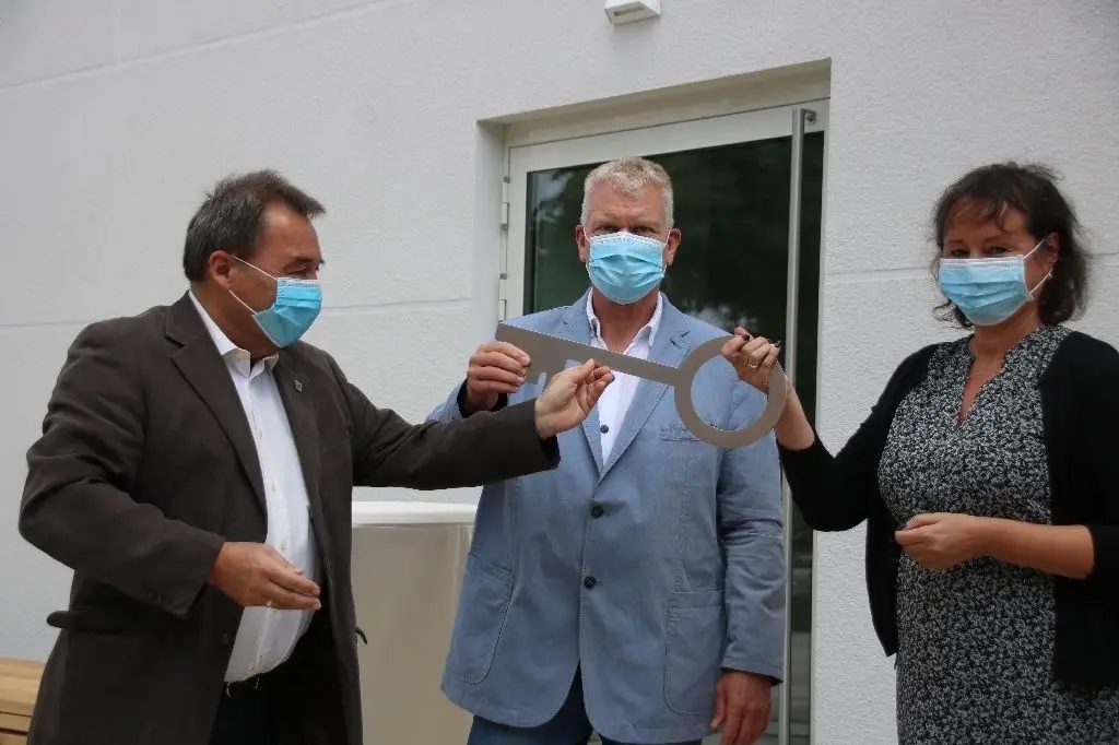 Bürgermeister Jürgen Hemberger (li.) übergibt den symbolischen Schlüssel an den Schulleiter und die Hortleiterin.