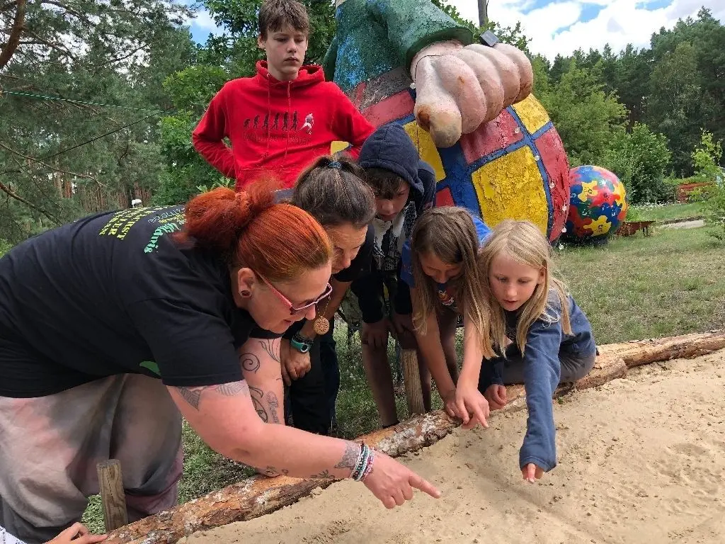 "Was sehr ihr da?": Antje Modespacher (links) weckt die Neugier der Kinder, welche Geschichte Spuren im Sand erzählen können.