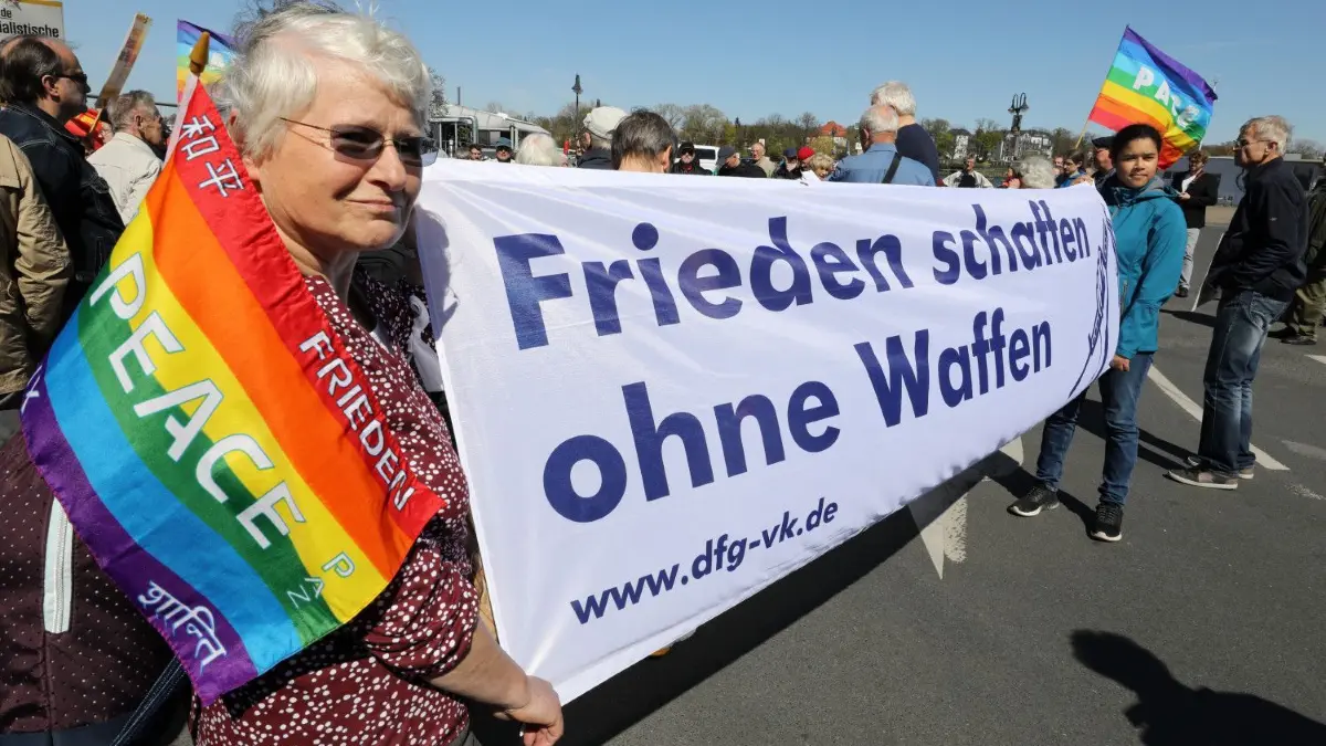 Hinter dem Motto „Frieden schaffen ohne Waffen“ versammeln sich auch in diesem Jahr Mitglieder der Friedensbewegung. Werden sie auf Resonanz stoßen?
ARCHIV - 20.04.2019, Mecklenburg-Vorpommern, Rostock: Mit Fahnen der internationalen Friedensbewegung versammeln sich die Teilnehmer am Ostermarsch, auf einem Transparent steht «Frieden schaffen ohne Waffen». (zu dpa: «Vor den Ostermärschen: Ist der deutsche Pazifismus tot?») Foto: Bernd Wüstneck/dpa-Zentralbild/dpa +++ dpa-Bildfunk +++