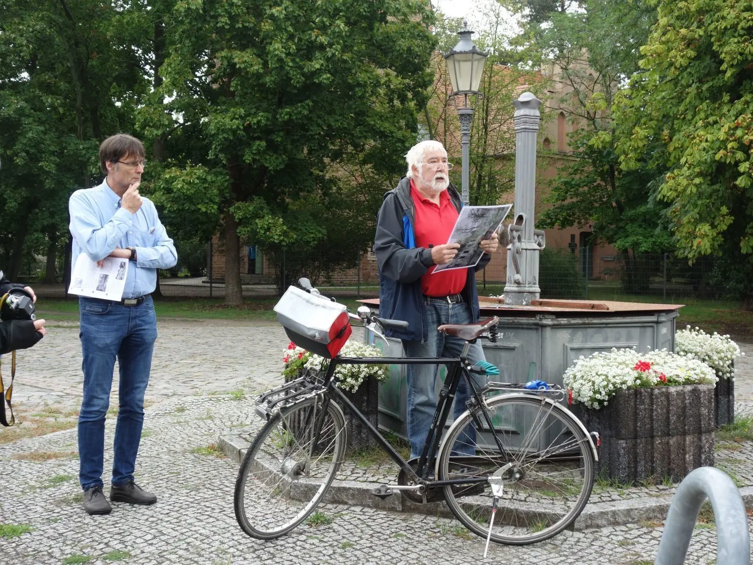 Auf dem Platz an der alten Stadthalle in Falkensee stand einmal ein Gutshaus. Thomas Lenkitsch (li.) und Klaus-Peter Mentzel erforschen nicht nur die Vergangenheit der Stadt, sie teilen ihre Erkenntnisse bei den historischen Radtouren.