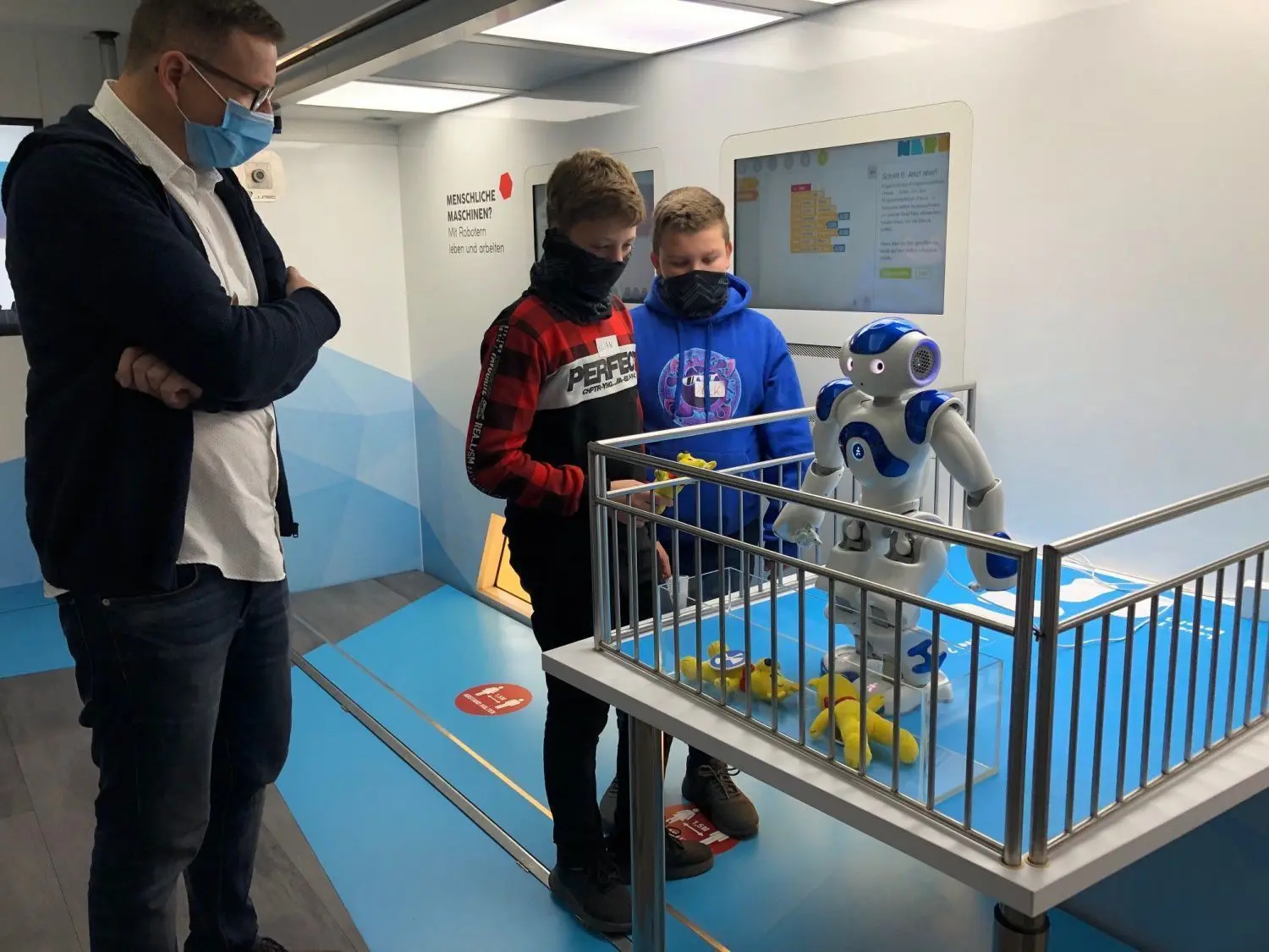 Nick Seipolt und Kilian Ney haben gerade einen Roboter programmiert. Bei ihnen: Kai Dammascheck von der Bundesagentur für Arbeit in Frankfurt