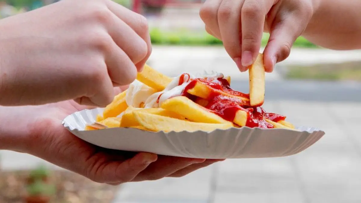Pommes und Freibad - zwei Unzertrennliche.
18.06.2020, Berlin: Kinder essen im Sommerbad Humboldthain Pommes mit Ketchup und Mayo vom Imbiss «Tropez». (zu dpa "Pommes: Warum kriegt man im Freibad Heißhunger drauf?") Foto: Christoph Soeder/dpa +++ dpa-Bildfunk +++