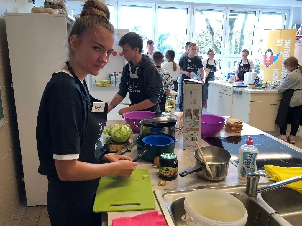 Ronya (hier beim Zwiebelschneiden) gehört zum vierköpfigen Koch-Team der Jean-Clermont-Schule Sachsenhausen. Sie kennt das Rezept aus dem Kopf.