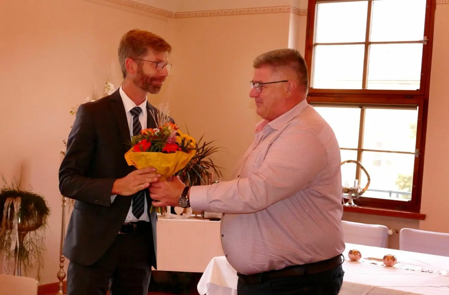 Alles entschieden - WAV-Chef Daniel Nicodem (l.) bekommt von Ronald Kühn, Vorsitzender der Verbandsversammlung, einen Blumenstrauß.