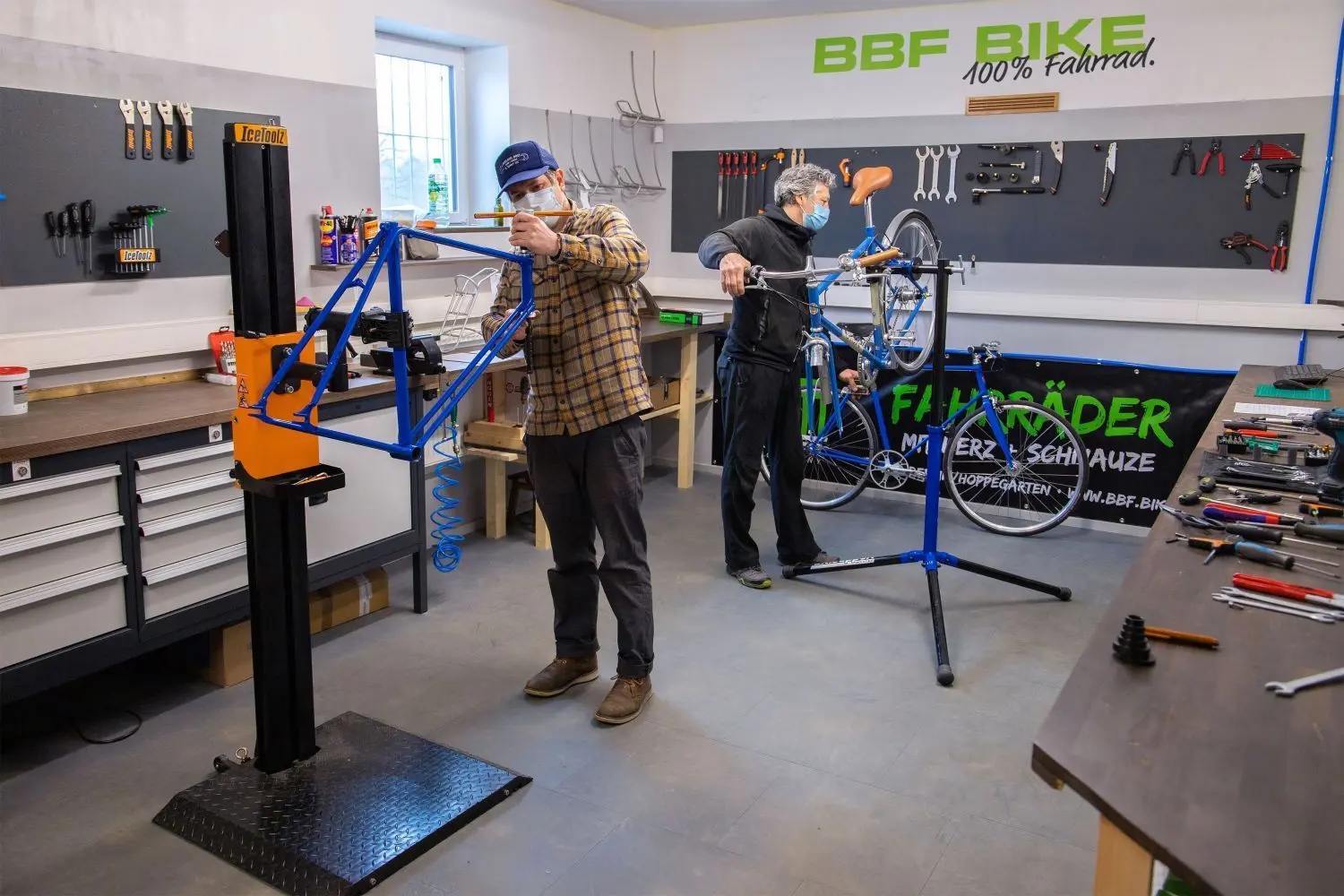 In der Fahrradwerkstatt von BBF Bike Hoppegarten bauen Robert Boede (vorn) und Michael Schott Räder zusammen.