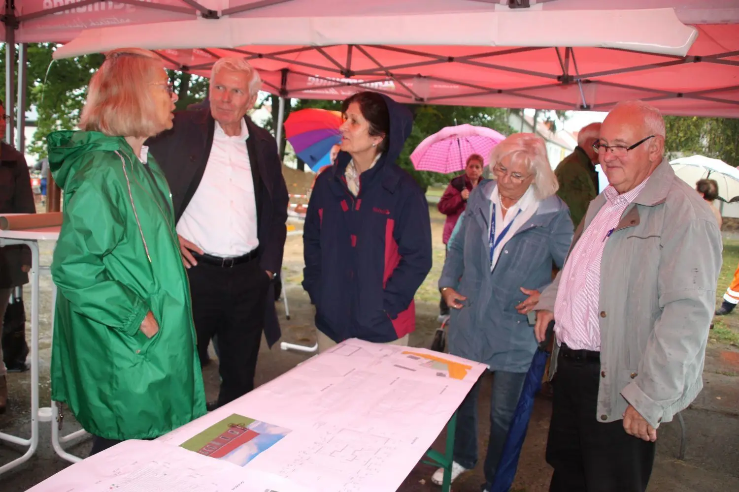 Grundsteinlegung für das Begegnungszentrum in Wolletz: Initiatorin Lisa Fiege, Architekt Jan Kleihues und Planein Elke Hähnel (v. l.) erläutern das Projekt interessierten Einwohnern.
