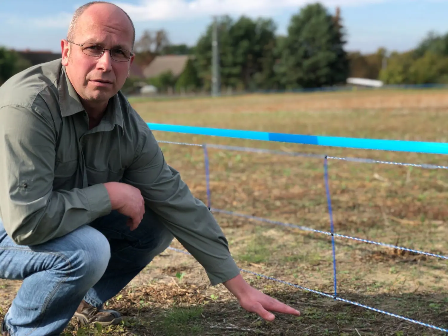 Kritisch beäugt: Dany Wittchen, Jäger aus Wellmitz, kritisiert den Weidezaun um die Kernzone der Afrikanischen Schweinepest. Die untere Litze ist nicht nahe genug am Erdboden.