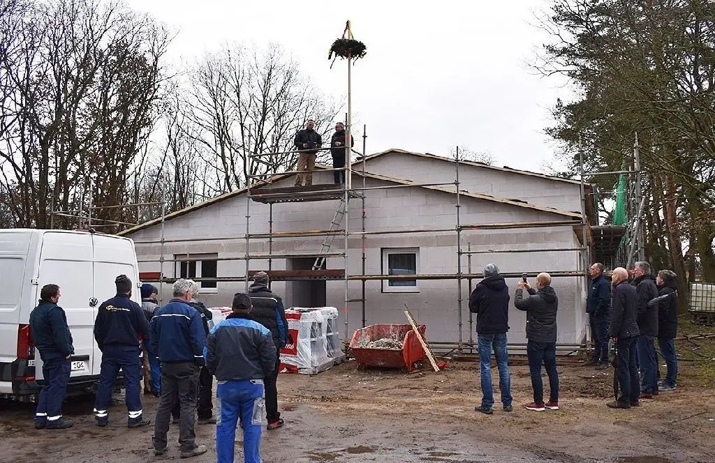 Trübes Wetter – freudiger Anlass: Über dem neuen Gebäude an der Breiten Allee schwebt die Richtkrone.