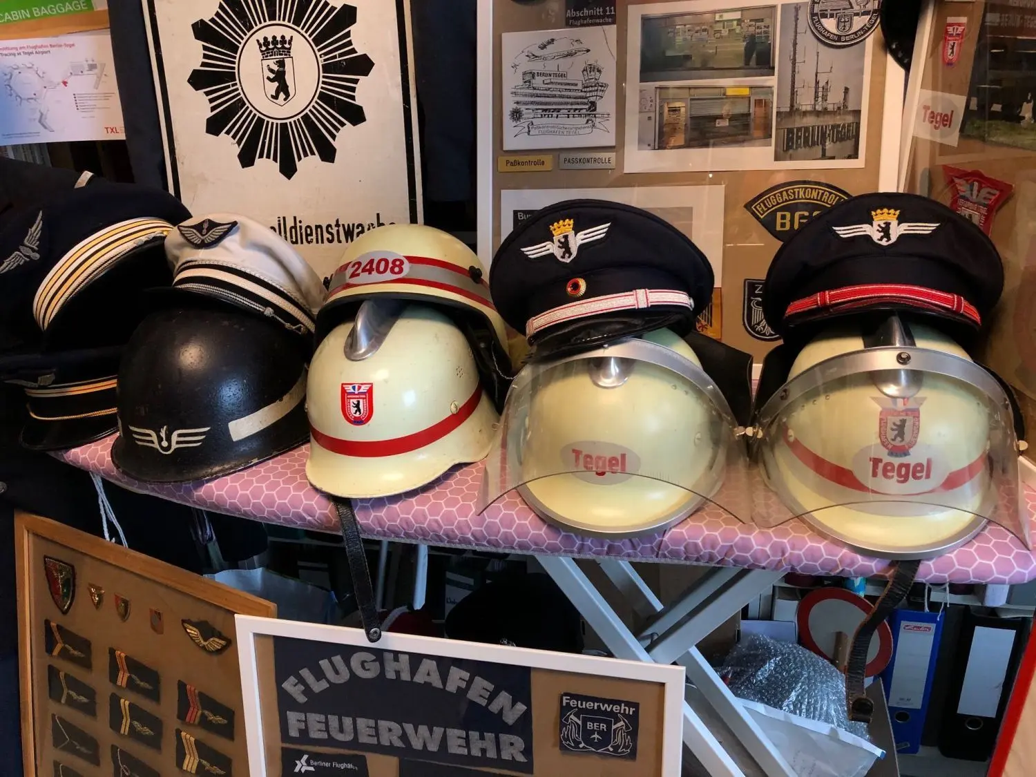 Im Wandel der Zeiten: links im Bild Kopfbedeckungen der französischen Alliierten, rechts die Helme der zivilen Flughafen-Feuerwehr