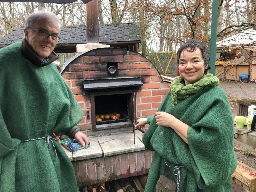 Rainer Reiher und Andrea Kaussmann (linkes Bild), Leiterin des Naturschutzzentrums Krugpark, beim winterlichen Grillen von Äpfeln.