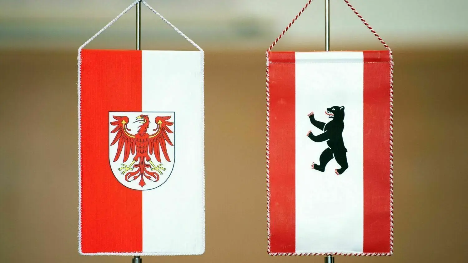 Die Wappen von Berlin und von Brandenburg, der Bär und der Rote Adler, auf den Fähnchen stehen auf dem Tisch. Bei dem ersten Treffen der Abgeordneten kam es zu unschönen Szenen.