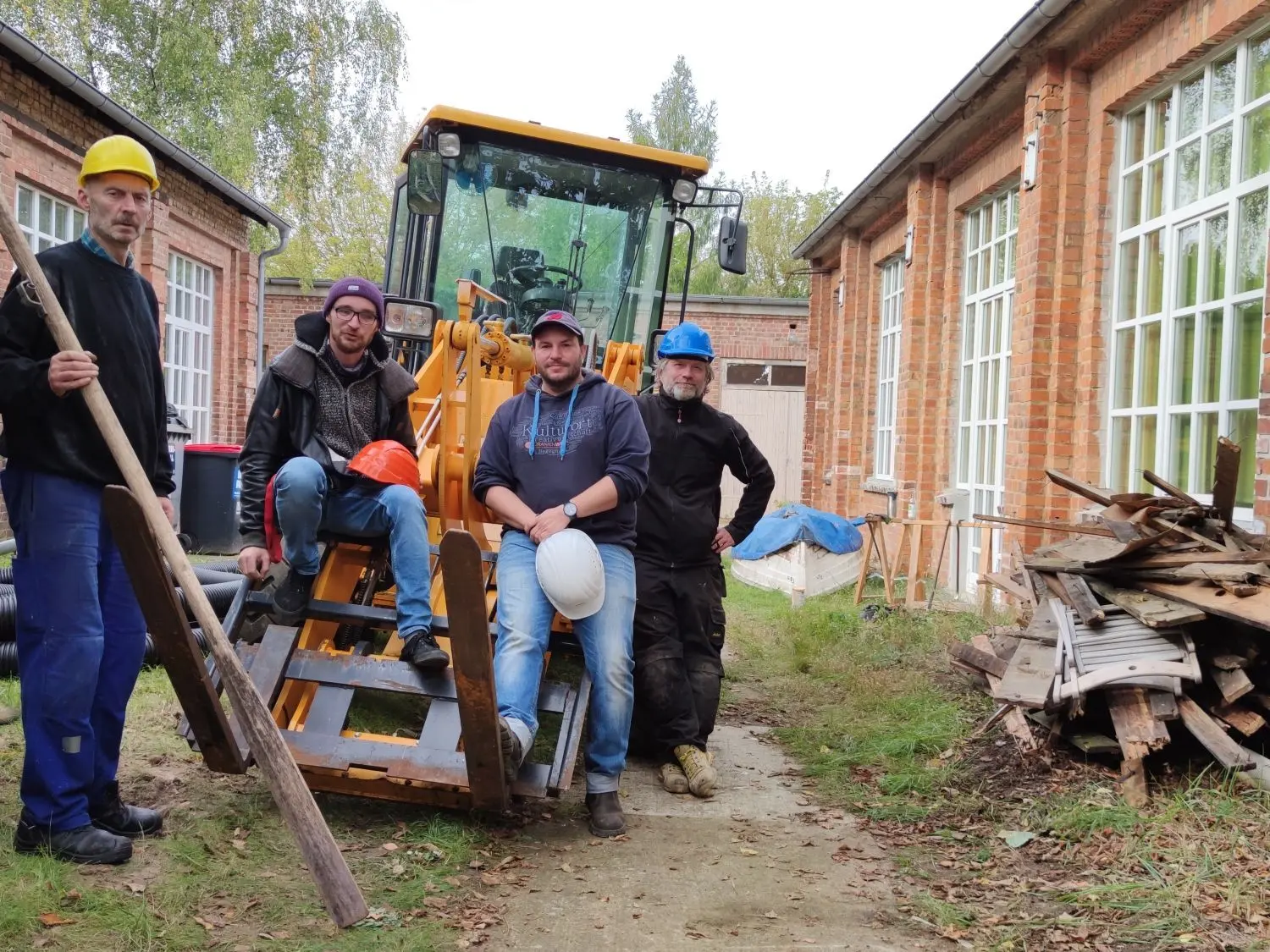 Frank Steinmüller, Marco Bartsch, Thomas Schenk und Hausmeister Uwe-Jens Sukow haben auch in Corona-Zeiten viel zu tun. Derzeit bauen sie ein Holzdach in einem Innenhof des Oranienwerks ab.