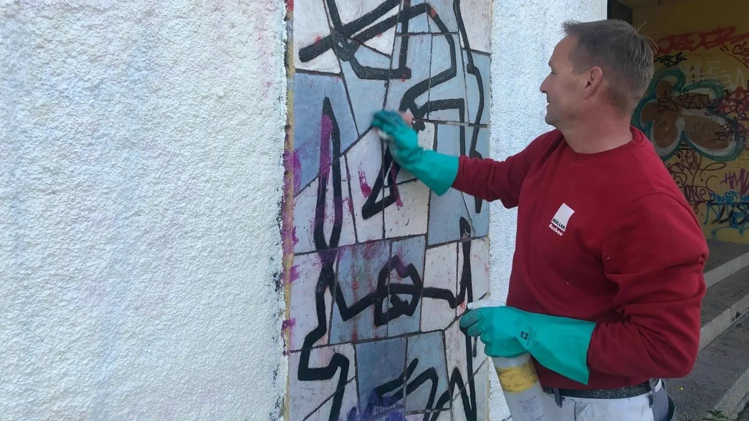 Sven Junker von der Graffitiwehr der Firma Müller Maler und Ausbau GmbH reinigt die Fassade an der ehemaligen Schule V am Platz der Jugend. Zuvor hat er die Nazi-Hetze und die Drohungen gegen P. (16) übermalt.