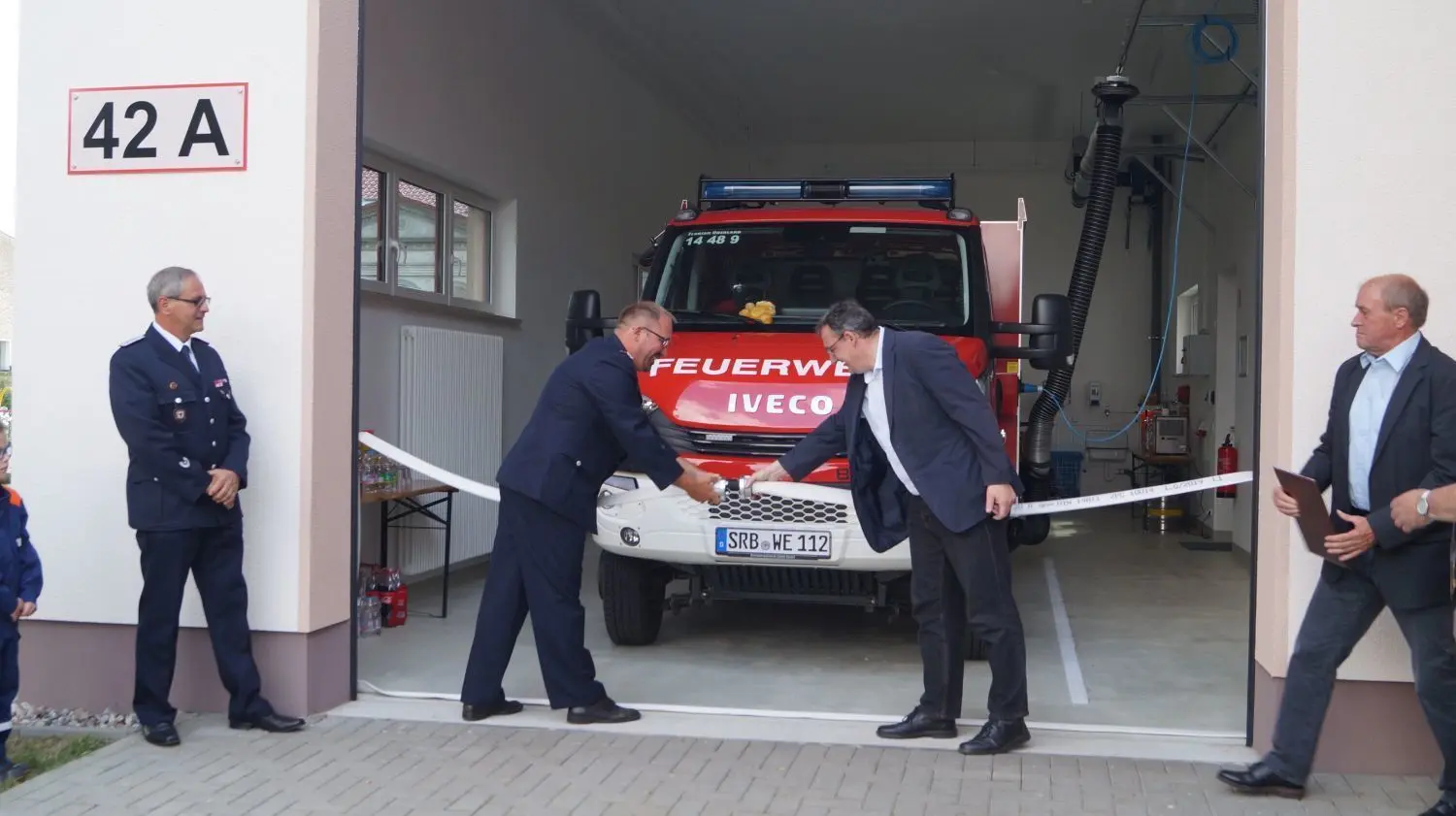 Investitionen in die Gebäude: Mit dem Lösen des Feuerwehrschlauches eröffnen Ortswehrführer Marc Witt (l.) und Amtsdirektor Marco Böttche erst im Sommer das neue Feuerwehrgerätehaus in Werder. Mit finalen Kosten von 745.000 Euro war es rund 40.000 Euro günstiger als veranschlagt.