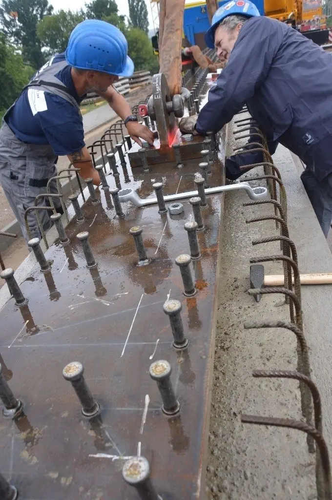 Stefan Voetsch und Jürgen Rosenthal befestigen den Träger am Haken des Schwerlastkrans.