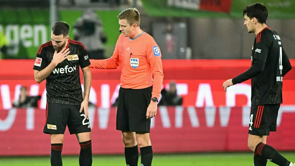 Niko Gießelmann (Union Berlin, links) bekam während des Spiels beim VfL Wolfsburg einen Hustenanfall.
Fussball, Herren, Saison 2022/2023, 1. Bundesliga (24. Spieltag), VfL Wolfsburg - 1. FC Union Berlin, v.l. Niko Gießelmann (1. FC Union Berlin), Schiedsrichter Robert Schröder und Diogo Leite (1. FC Union Berlin) , 12.03.2023, Foto: Matthias Koch