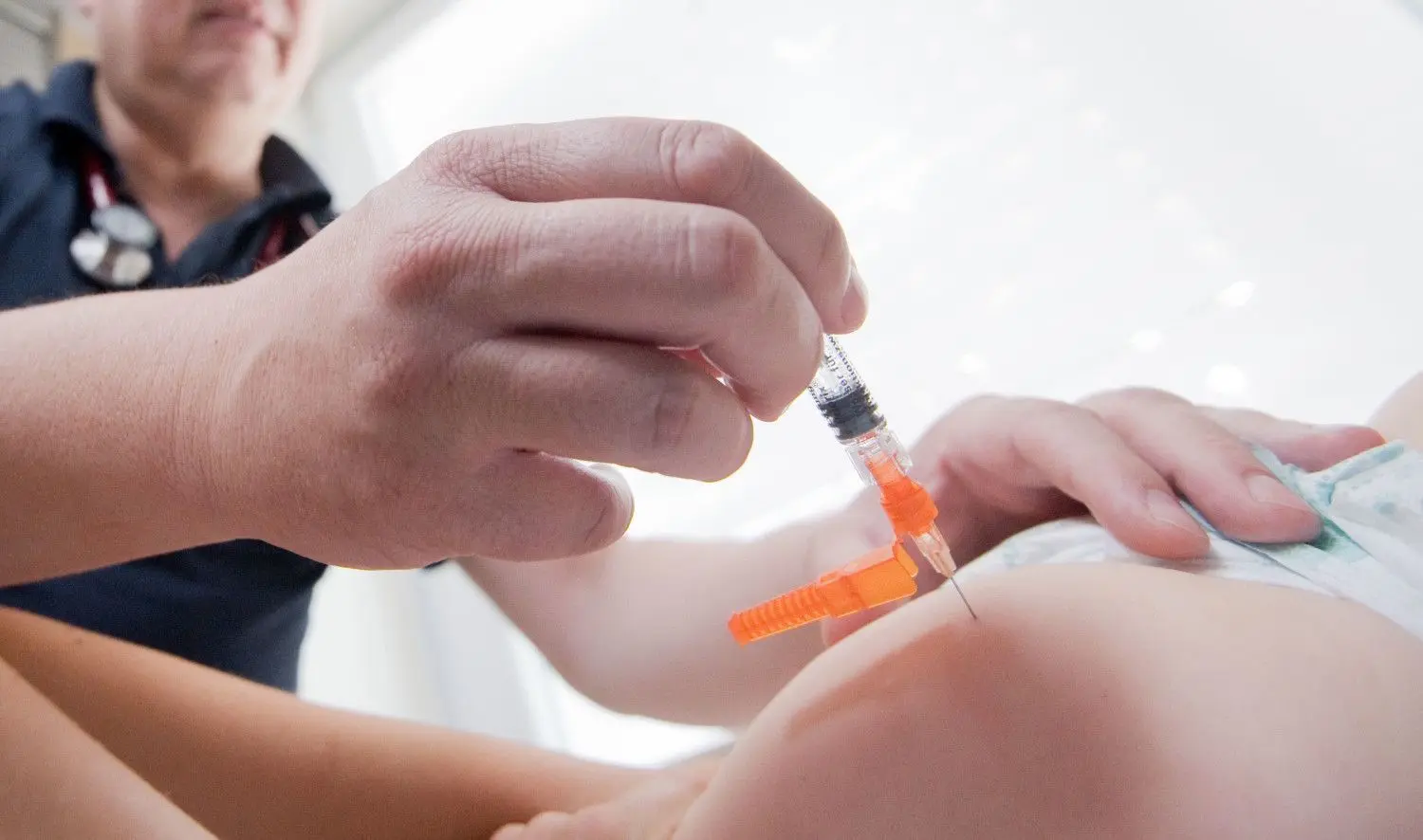 Ein Kinderarzt impft ein einjähriges Kind in den Oberschenkel gegen Masern, Mumps und Röteln. In Kürze sollen Kinder auch gegen Corona geimpft werden können.