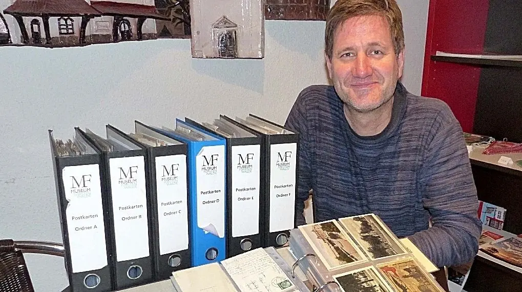 Acht Ordner mit historischen Postkarten aus der Region: Für Museumsleiter Guido Strohfeldt ist die umfangreiche Sammlung eine wichtige Bildquelle der Lokalgeschichte. Und sie gibt Auskunft über die wechselnden Gestaltungsprinzipien für die Karten.