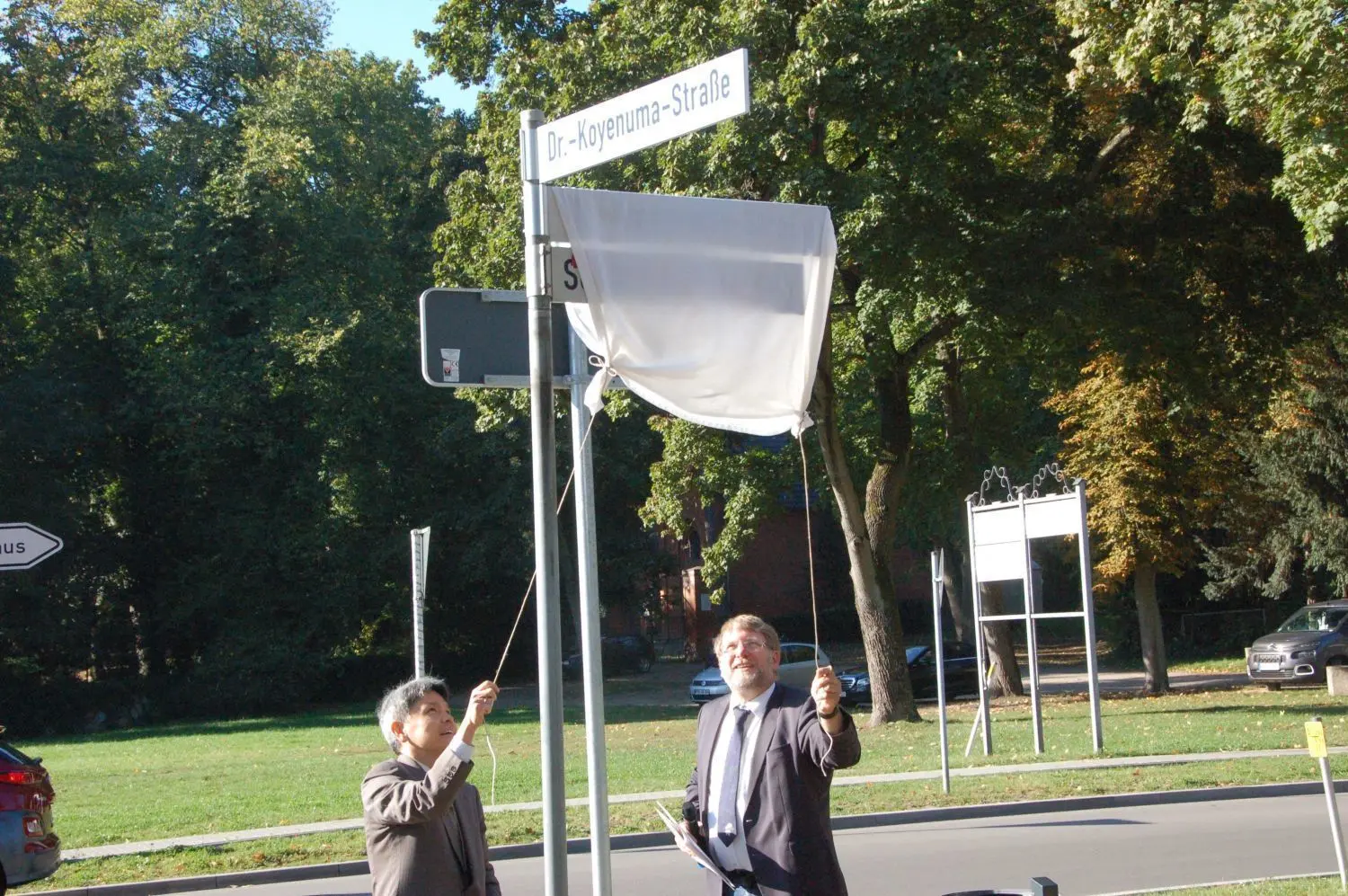 Straße nach Ehrenbürger benannt: Der japanische Gesandte Shinya Fujita und Wriezens Bürgermeister Karsten Ilm (CDU) enthüllen das Straßenschild.