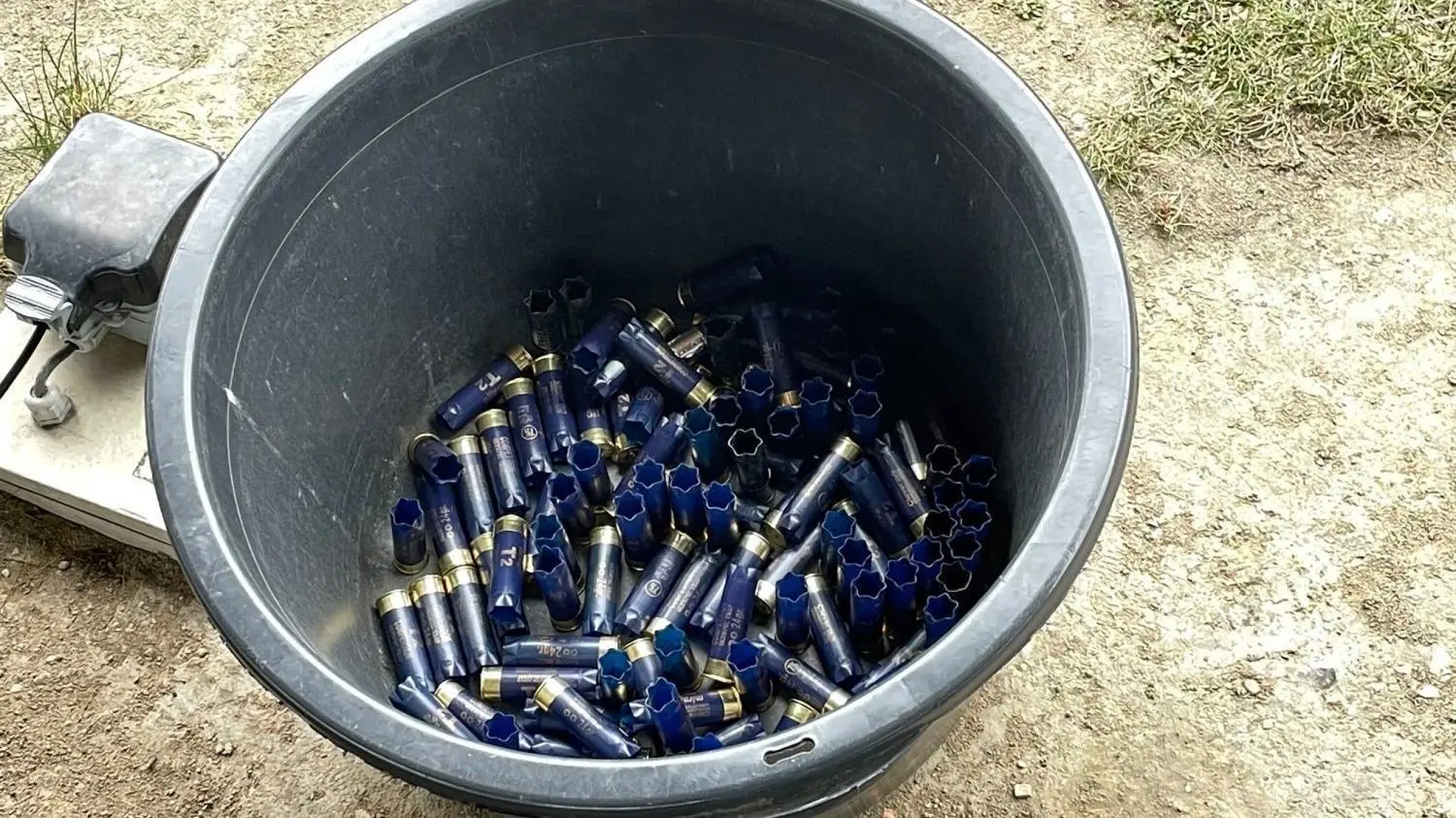 Ein Eimer mit verschossenen Schrotpatronen für Flinten am Schießstand