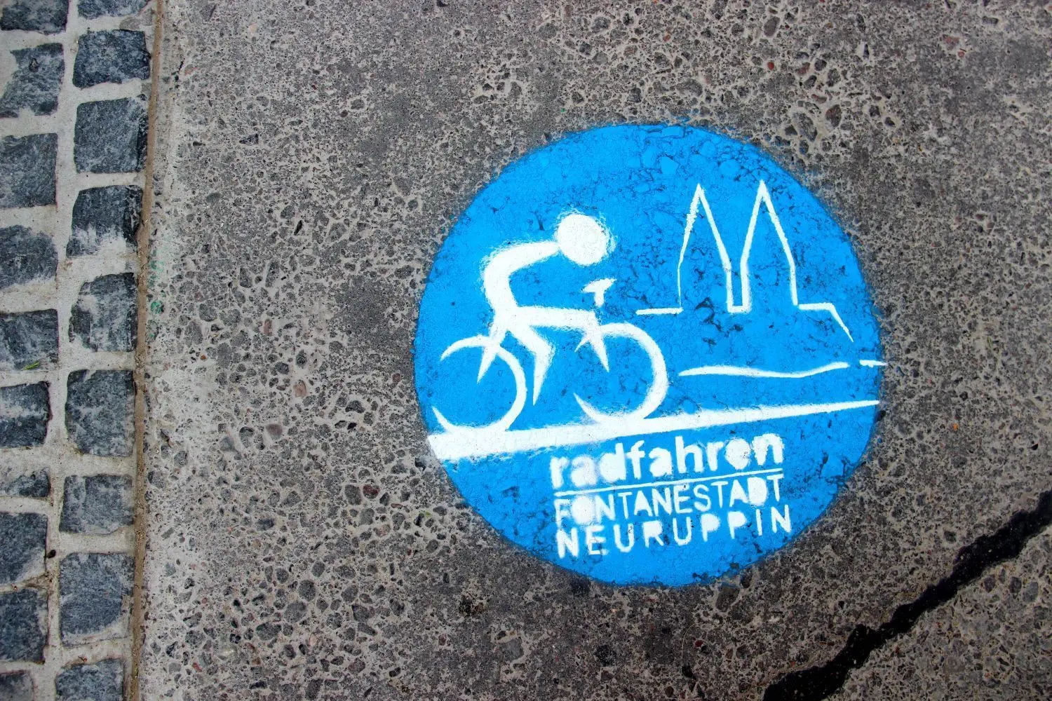 Das Logo der AG Fahrradfreundliche Kommunen: Dieses Graffitti wurde auf eine der Neuruppiner Straßen gesprüht. Die Kreisstadt des Landkreises Ostprignitz ist Mitglied der Arbeitsgemeinschaft.