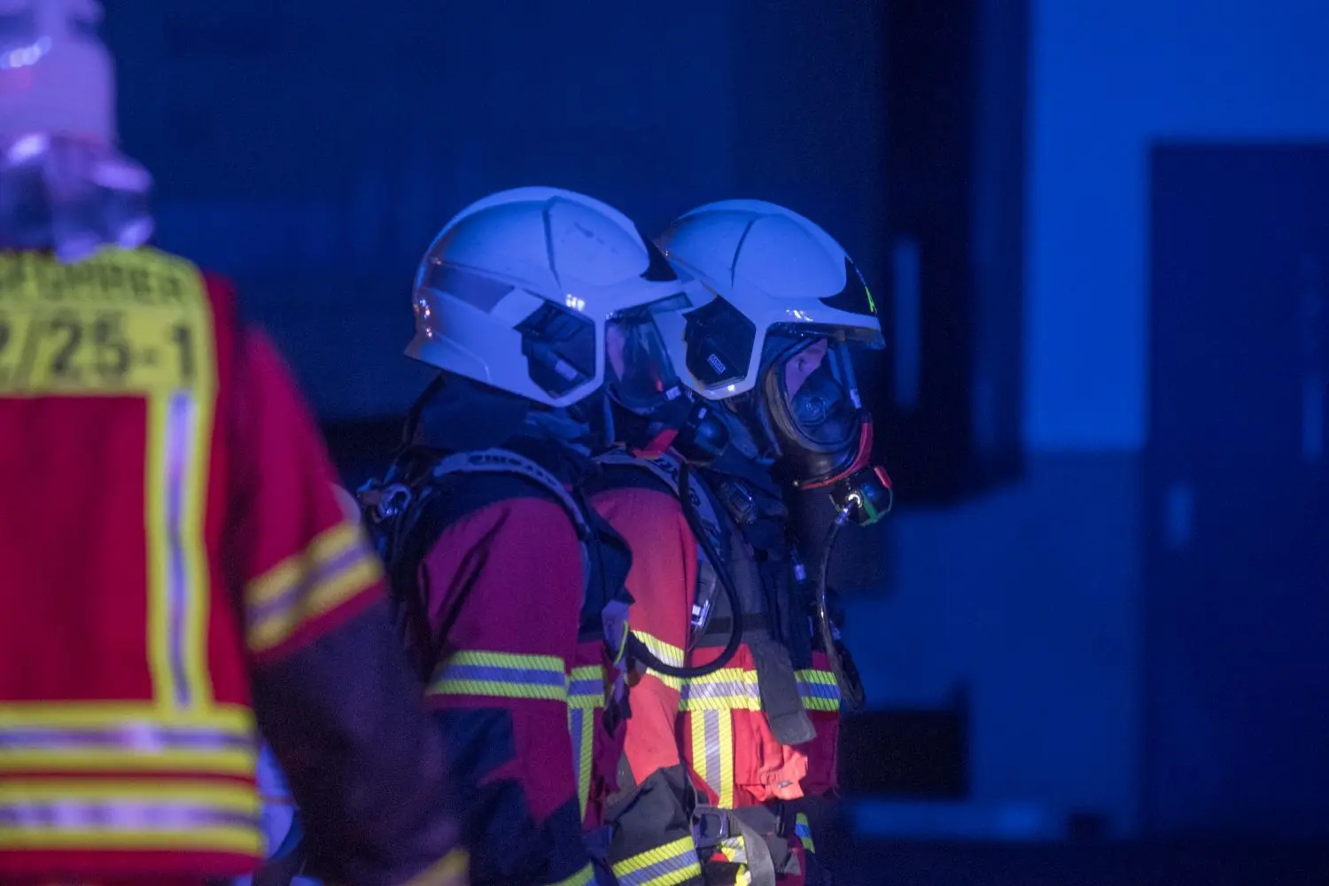 Die Feuerwehr arbeitet mit Atemschutz an der Einsatzstelle.