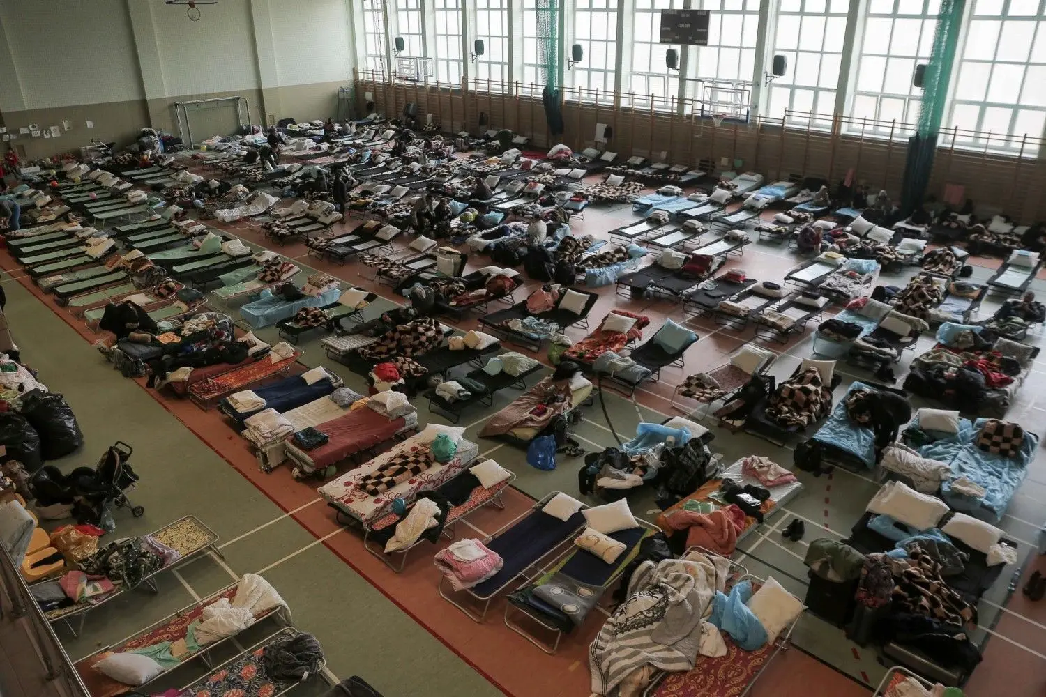 Hunderte von Betten stehen in einer Sporthalle, wo sie aufgestellt wurden, um ukrainische Flüchtlinge, die vor der russischen Invasion fliehen, am polnischen Grenzübergang Medyka unterzubringen.