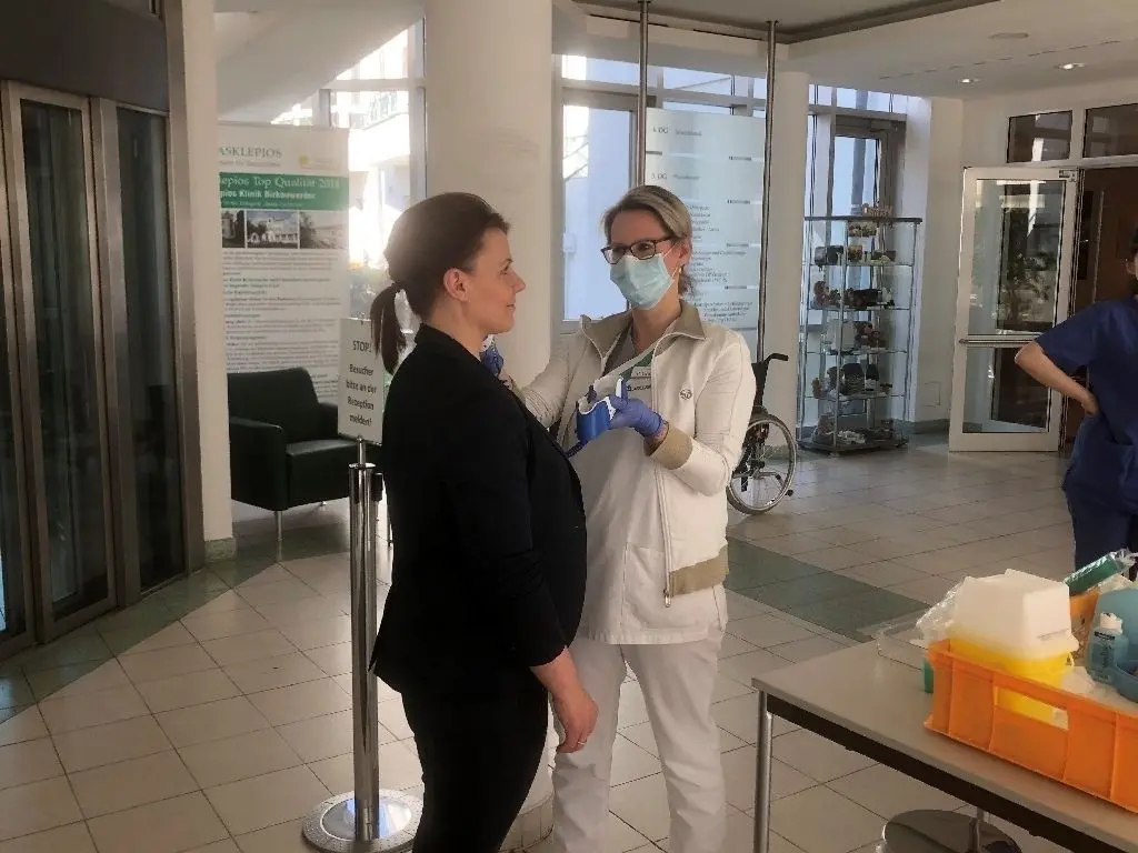 Jeder Besucher wird in der Eingangshalle der Asklepios Klinik auf Symptome getestet. Unser Bild zeigt Schwester Pamela Krieger, die bei der Mitarbeiterin Janita Schablin Fieber misst.