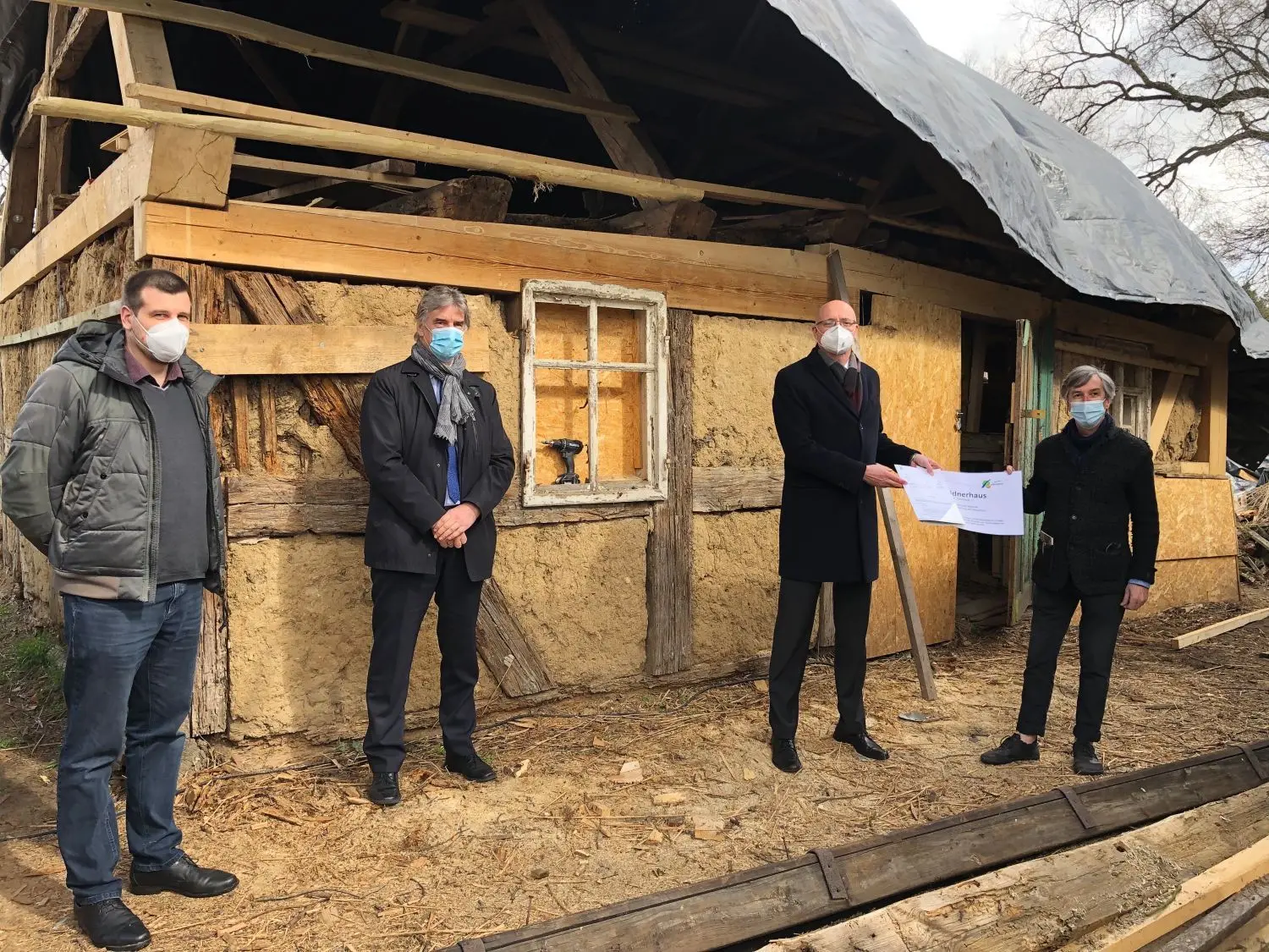 Hilfe zur Selbsthilfe: Einen Fördermittelbescheid über etwa 24.000 Euro bekam Joachim Faitsch (rechts) von Landrat Ludger Weskamp überreicht. Auch Baudezernent Egmont Hamelow und der zuständige Mitarbeiter für Denkmalschutz, Martin Petsch (links) erklärten die alte Bausubstanz für erhaltenswert.