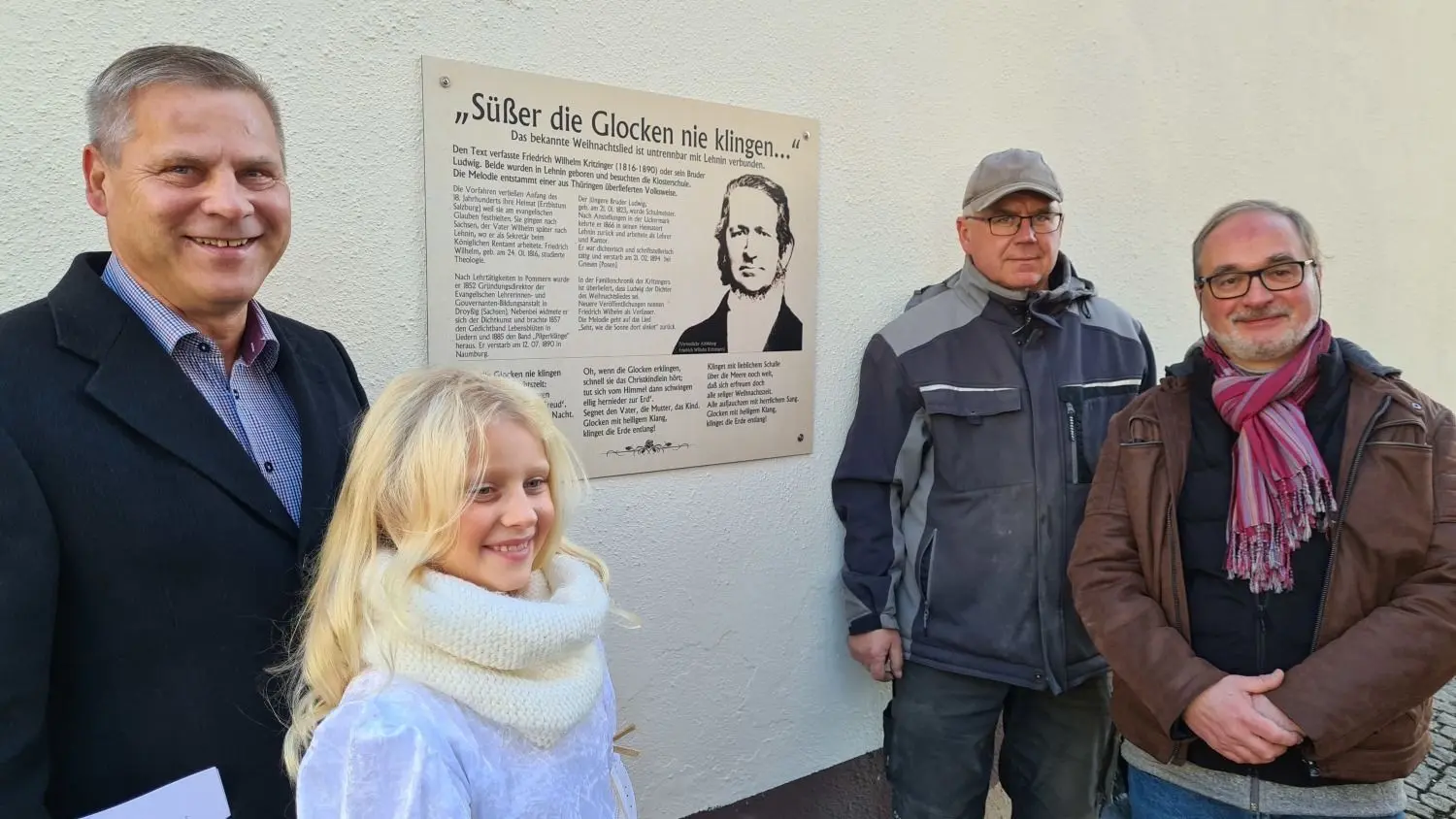 Bürgermeister Uwe Brückner, Engel Levke, Ortsvorsteher Frank Niewar und Musiker Andreas Behrendt (v. l.) haben die Gedenktafel für die Gebrüder Kritzinger in der neuerdings nach ihnen benannten Gasse enthüllt.